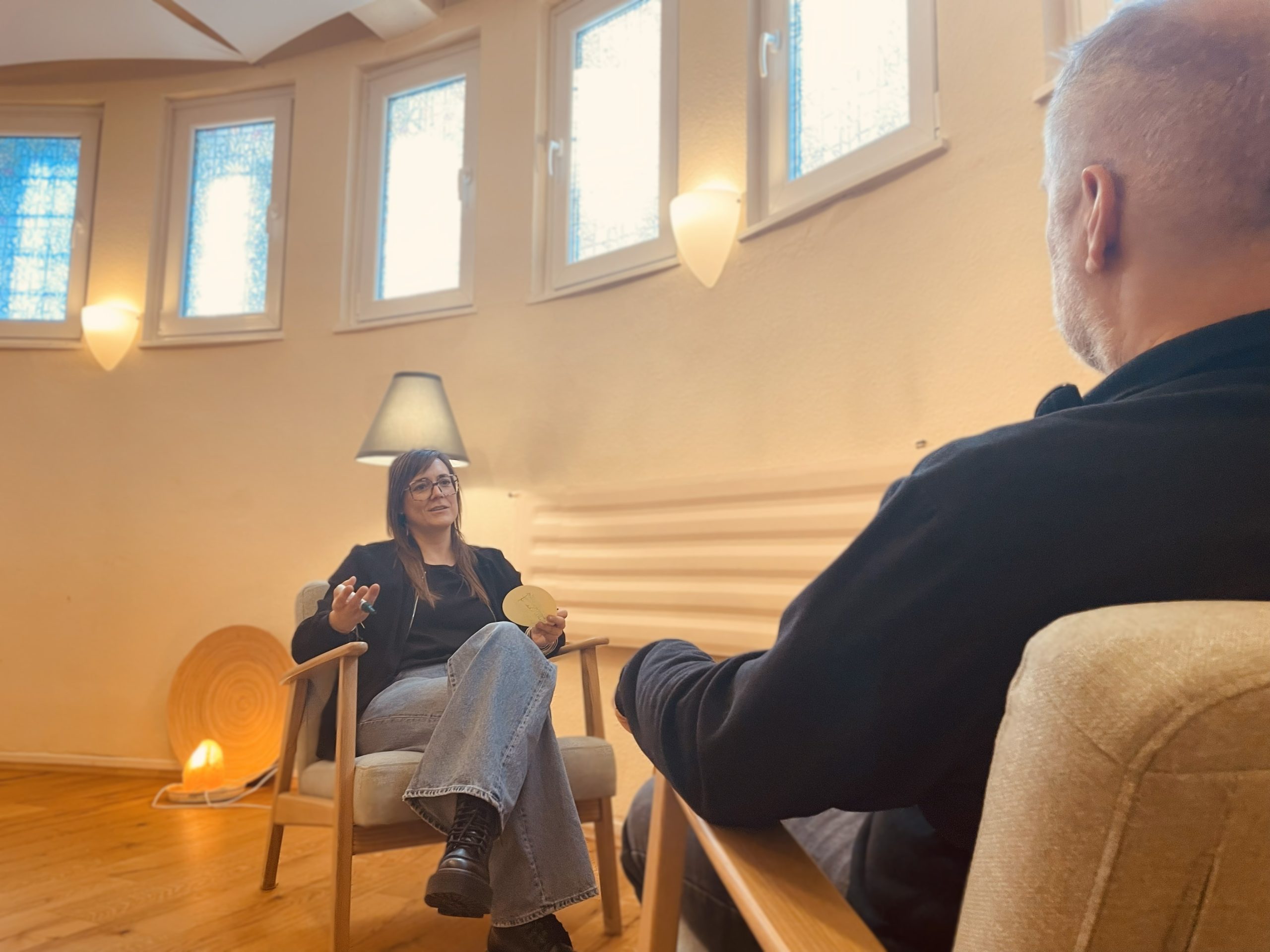 Frau sitzt auf einem Sessel im Einzel-Beratungskontext
